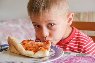 bir çocuk pizza bir dilim yiyor