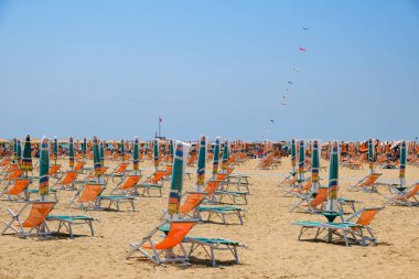 Bir İtalyan plajında kapalı şemsiye ve şezlong