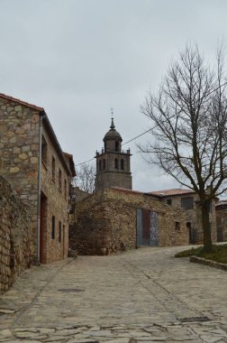 Taş evlerin üstündeki Medinaceli köyü katedralde çan kulesi görebilirsiniz. Mimari, tarih, seyahat. 19 Mart 2016. Medinaceli, Soria, Castilla Leon, İspanya.