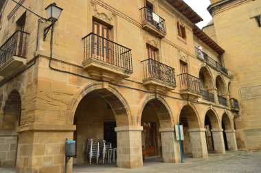 Plaza Mayor Briones bulutlu bir günde üzerinde kemerli güzel portallar. Mimari, sanat, tarih, seyahat. 27 Aralık 2015. Briones, La Rioja, Spain.