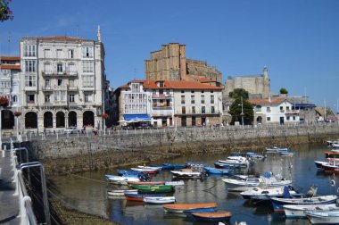 Güzel balıkçı limanı, kilise 'nin dibine ve Castrourdiales 'Teki kaleye bakmaktadır. 27 Ağustos 2013. Castrourdiales, Cantabria, Ispanya. Tatil doğa sokak fotoğrafçılığı.