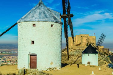 Consuegra 'da arka planda şatosu olan iki yel değirmeni. 26 Aralık 2018. Consuegra Toledo Castilla La Mancha İspanya Avrupa. Seyahat Turizmi Sokak Fotoğrafçılığı.