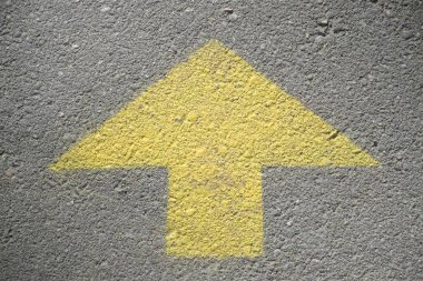 Yellow arrow on asphalt 