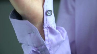 Bir adam bir düğme kol üzerinde takılır.