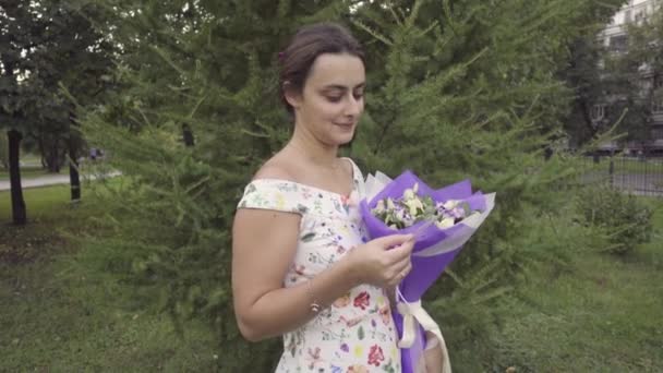 Ung flicka med en bukett blommor — Stockvideo