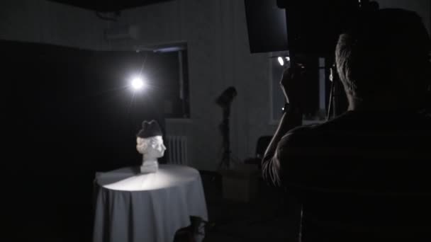 Ingeniero de iluminación en el conjunto ajusta el brillo del proyector — Vídeos de Stock