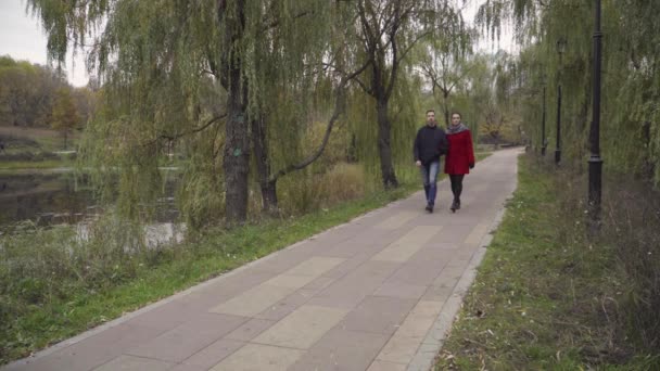 Man och kvinna går i parken — Stockvideo