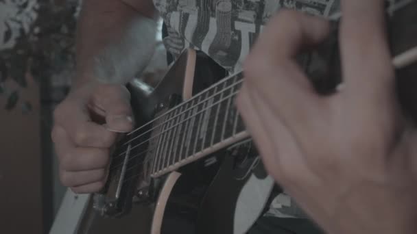 A man plays a black electric guitar — Stock Video