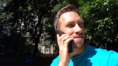 bir cep telefonuyla konuşan adam