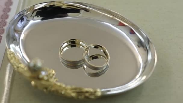 Anéis de casamento estão em um pires de metal — Vídeo de Stock