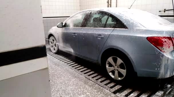 O carro na lavagem do carro é coberto com espuma branca — Vídeo de Stock