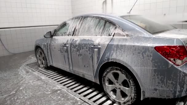 Con l'auto in macchina lavare via la schiuma con un getto d'acqua — Video Stock