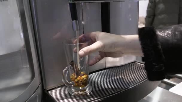 Într-un pahar de ceai de boabe și scorțișoară se toarnă apă clocotită dintr-un răcitor — Videoclip de stoc