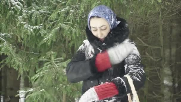 冬天森林里的女孩从雪地里洗衣服 摇一摇雪 — 图库视频影像