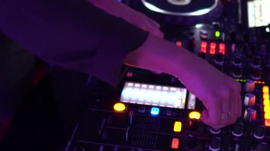 Kız Dj dans ve bir gece kulübünde müzik enstalasyon düğmelerine basarak. Dj ayarında, ışıklar titreşir.