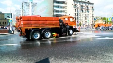 Sulama makineleri, tıkanmış şehir merkezindeki bir sütunda birbiri ardına gider ve yolu güçlü su akıntıları ile sular. Moskova, Mayıs 2019