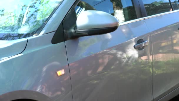 Egy férfi kikapcsolja az autóriasztó, kinyitja az ajtót — Stock videók