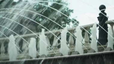 Fıskiyelerin ince jetleri ön planda bir yay içinde üst üste akar.