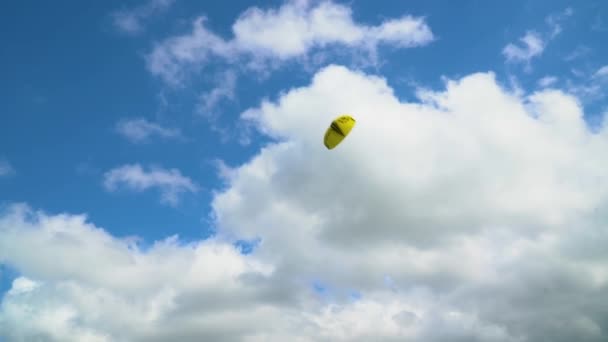 Lancio di un aquilone giallo contro un cielo nuvoloso . — Video Stock