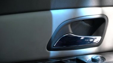 Arabadaki adam kapı kolunu çekiyor.