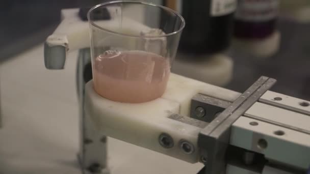 Робот несет стакан розовой жидкости — стоковое видео