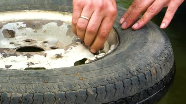 O homem torce a tampa mamilo velho carro roda — Vídeo de Stock