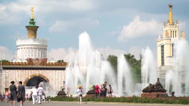 Duża fontanna z wysokimi dyszami na placu miasta, gdzie ludzie chodzą — Wideo stockowe