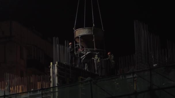 En la noche constructores canal mezclador de construcción, suspendido de una grúa — Vídeo de stock