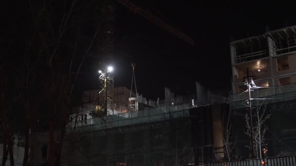V nočním stavitelství jeřáb drží hmotnost betonového mixeru — Stock video
