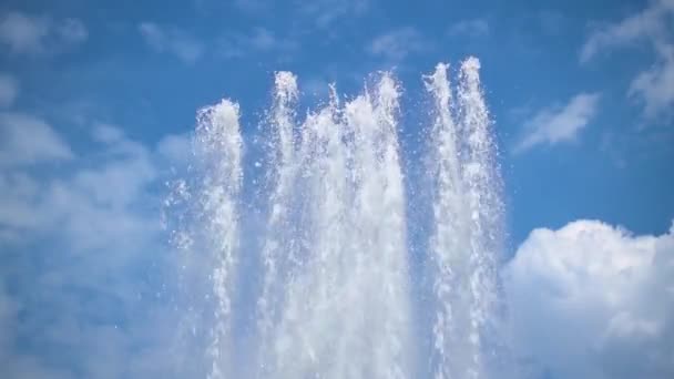 Kilka dysz fontanny w zwolnionym tempie na błękitne niebo z białymi chmurami — Wideo stockowe