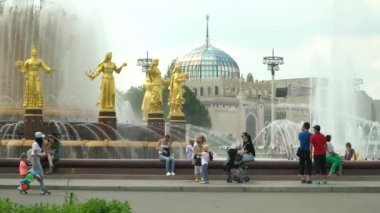 İnsanlar güneşli bir günde çeşmenin yanında oturun. Moskova, Haziran 2019