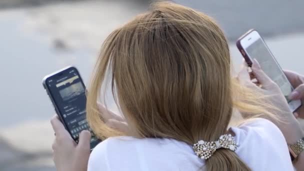 La chica sostiene un teléfono móvil y mensajes de texto en el mensajero — Vídeo de stock