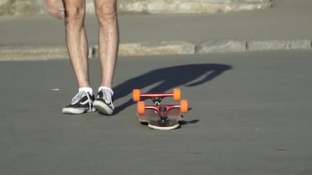 Der Kerl tritt das Skateboard, überschlägt es und fährt — Stockvideo