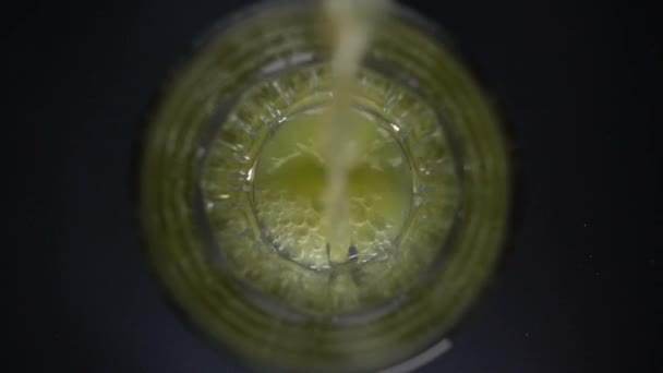 В стакан в замедленной съемке наливают апельсиновый сок — стоковое видео
