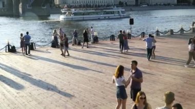 İnsanlar gün batımında rıhtımda dans ediyorlar. Moskova, Temmuz 2019