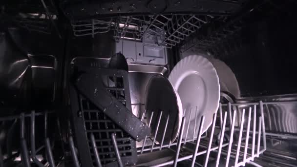 O homem abre a porta da máquina de lavar louça e puxa um cesto de pratos — Vídeo de Stock