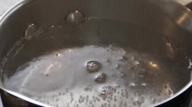 Bir tencerede, su yavaş yavaş ısınır, buhar yayar ve kaynamaya başlar.