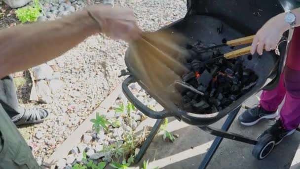 Im Grillventilator heizen Feuer und Zange die Kohle an — Stockvideo