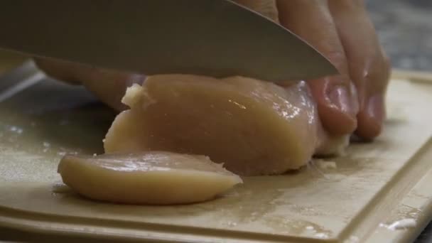 Muž krájí kousky masa z kuřecího řízku — Stock video