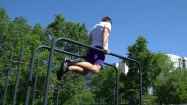 Adam sokakta antrenman yapıyor, barlarda şınav çekiyor.