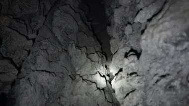 Fenerlerin ışınları mağaradaki çatlağı aydınlatıyor.