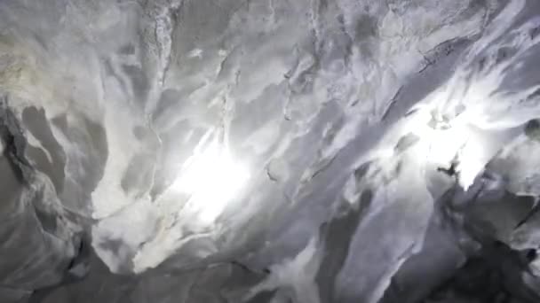 Лучи фонарей освещают потолок в пещере — стоковое видео