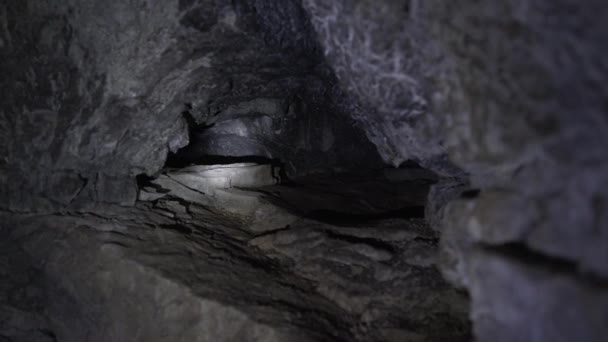 Lyktornas strålar lyser upp ett djupt hål i grottan. — Stockvideo