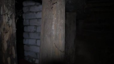 Bodrumdaki ışık, evin üzerinde durduğu ahşap destekleri aydınlatıyor.