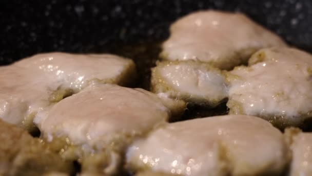 De oliebelletjes in de pan waar het vlees gebakken is — Stockvideo