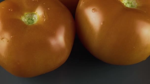 Три красных помидора на тарелке — стоковое видео