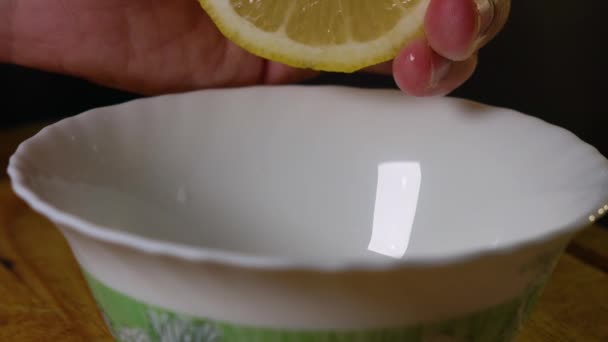 Exprimir a mano limón y jugo de limón en un tazón — Vídeo de stock