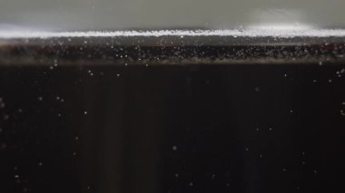 Karbonatlı kola kabarcıkları kadehte yavaşça yüzer.