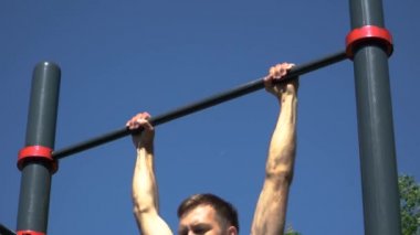 Adam güneşli bir günde barın önünde durur..