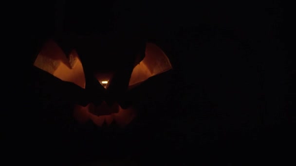 Zucca per Halloween con un viso sinistro sfarfallio con una luce arancione — Video Stock